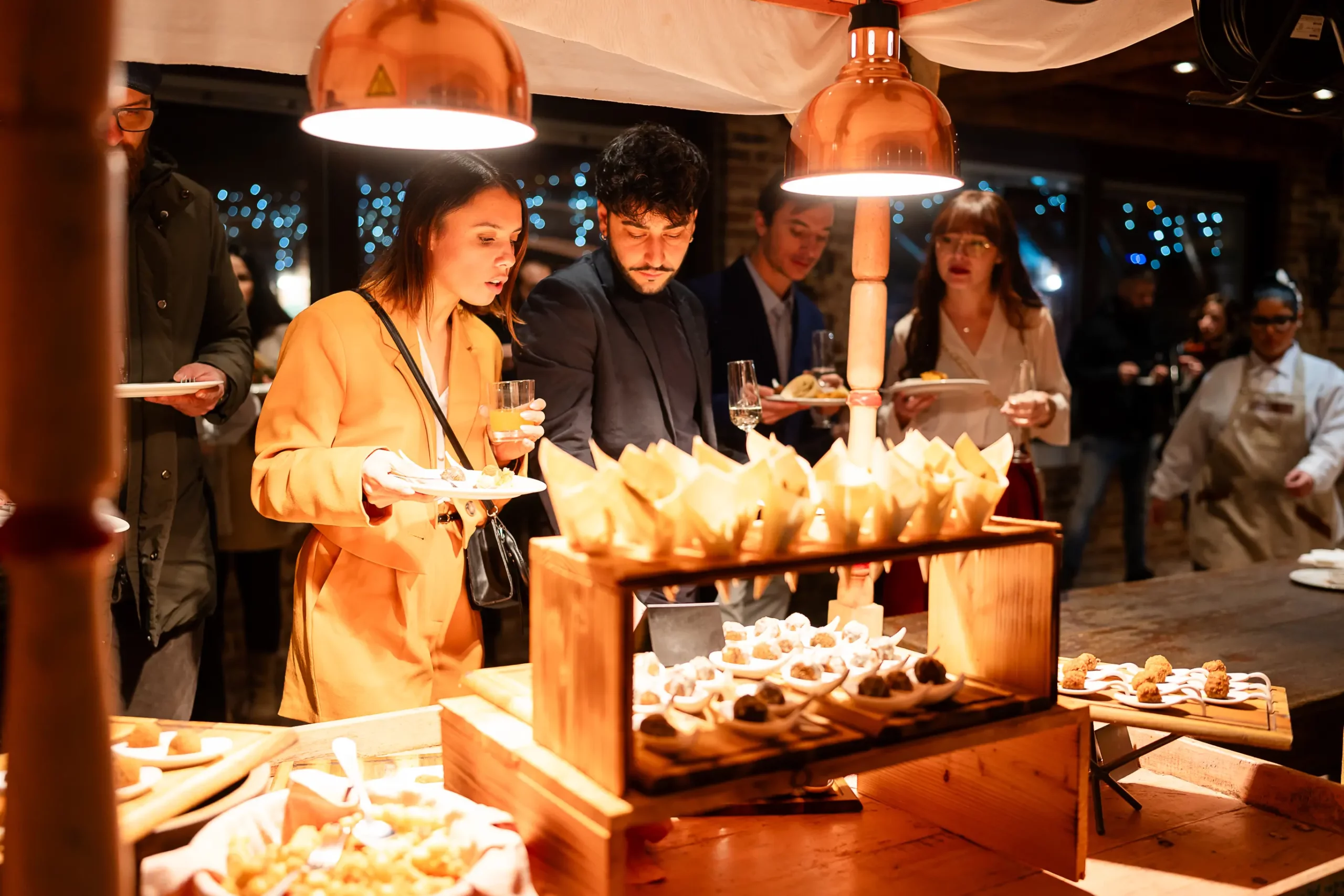 Invitati scelgono gli assaggi dal carretto buffet durante un ricevimento serale