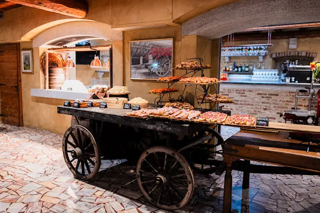 Buffet con formaggi, bruschette e panini servito sui carretti rustici della Veranda.