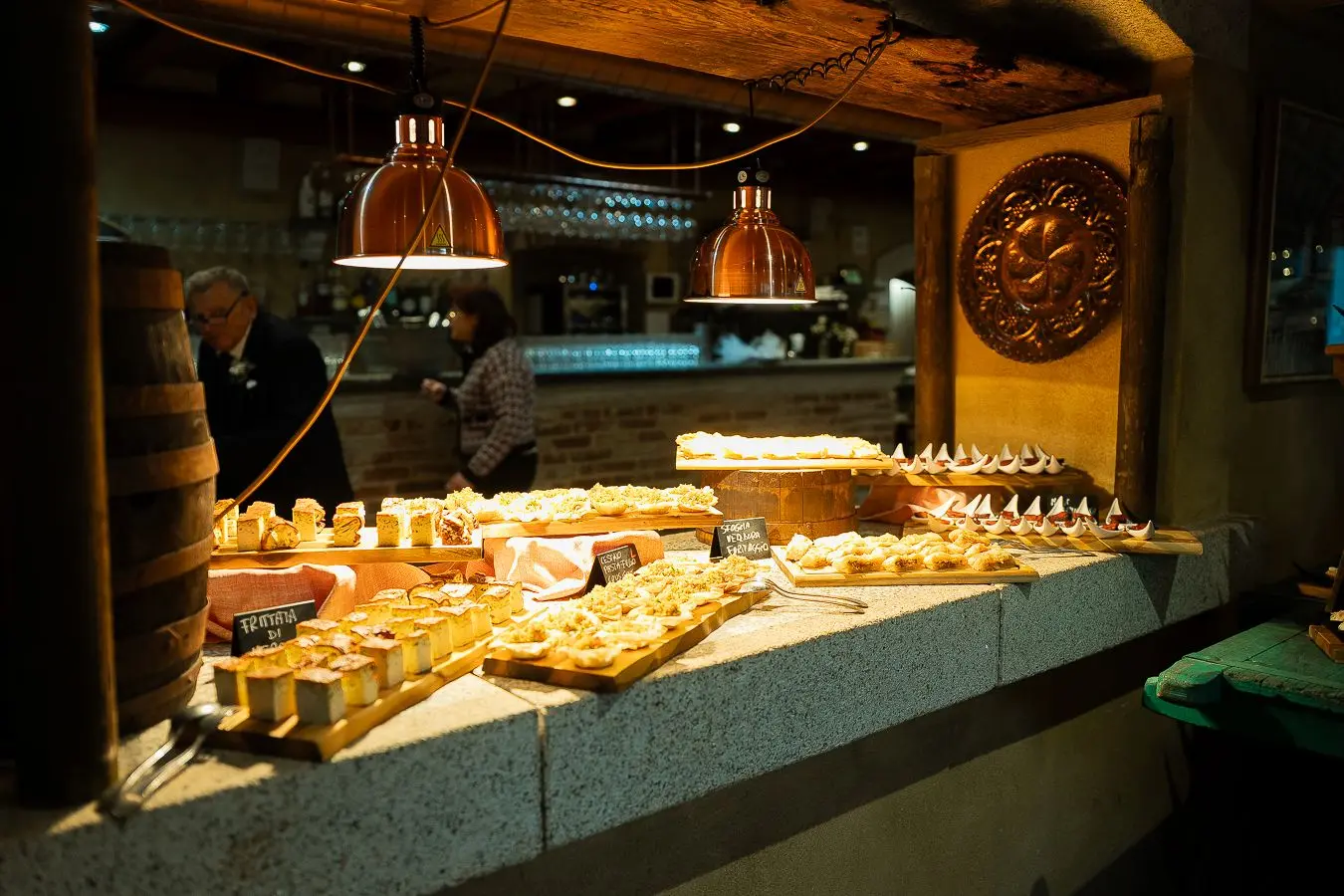 Buffet serale illuminato da lampade in rame nella Veranda
