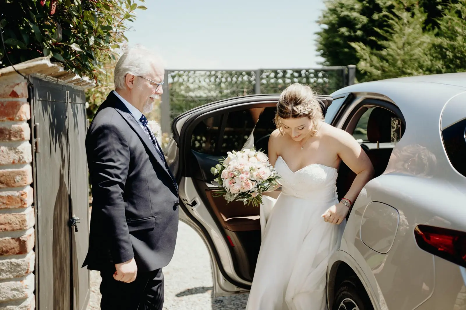 Sposa con bouquet mentre scende dall’auto all’arrivo all’Antico Ristoro del Ticino