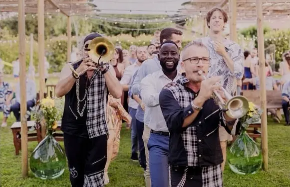 Banda musicale con trombe accompagna gli invitati nel giardino della Tela Verde