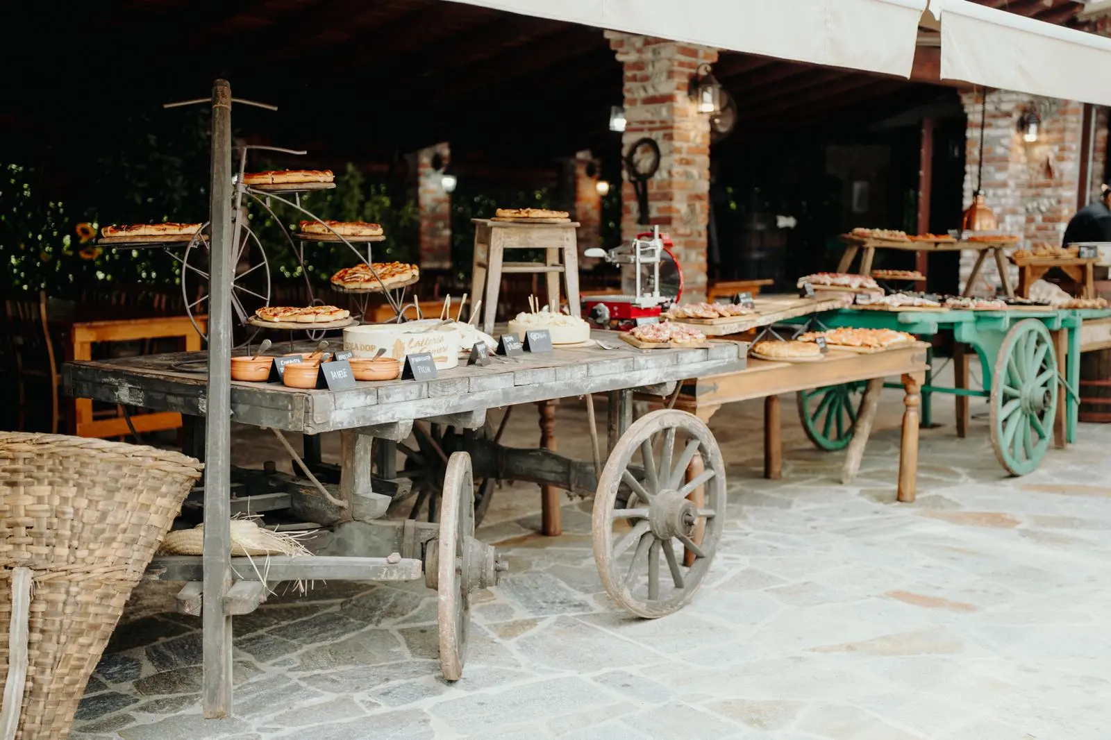 Buffet di matrimonio allestito su carretti rustici sotto il porticato