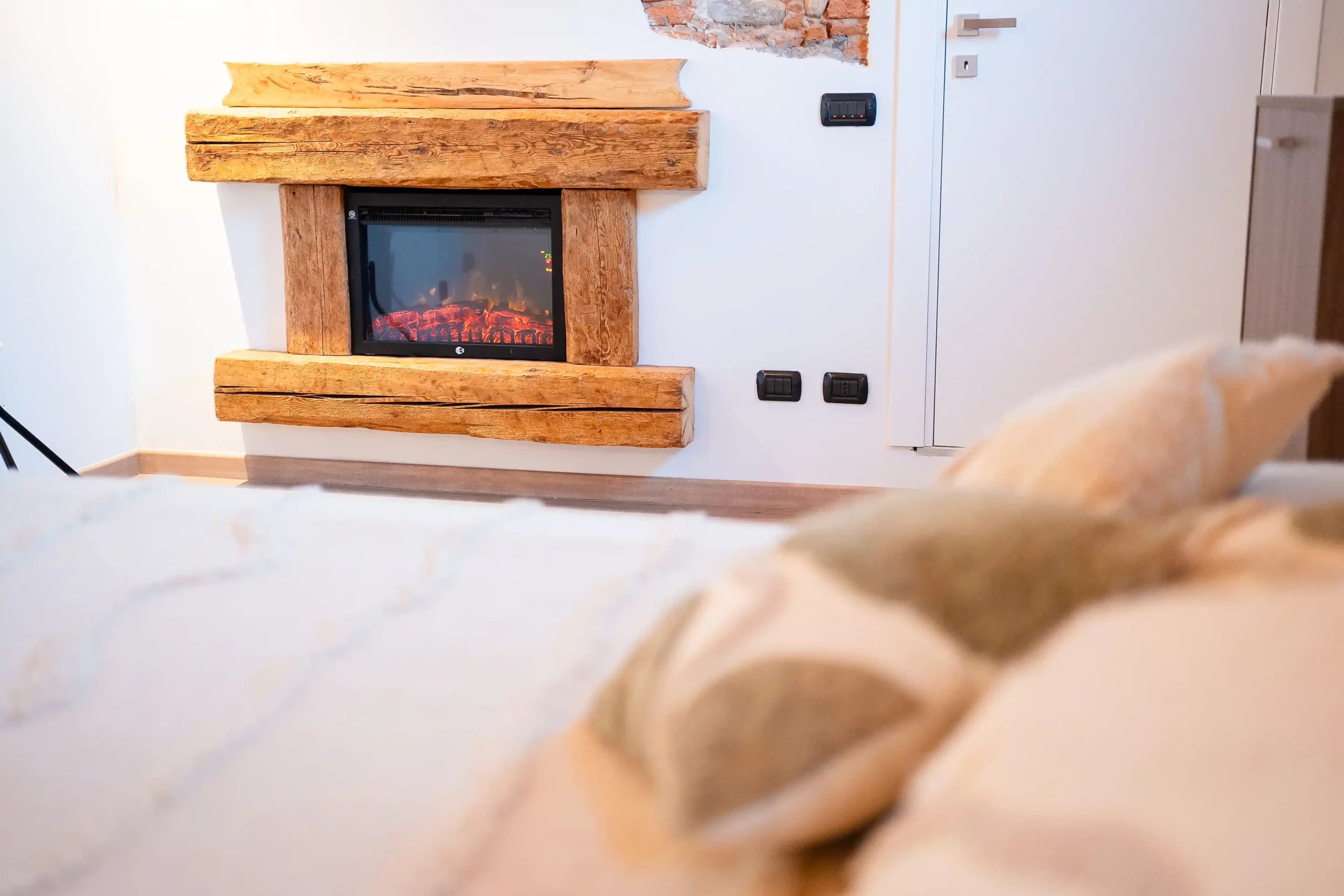 Camino con cornice in legno all’interno di una camera dell’Antico Ristoro del Ticino