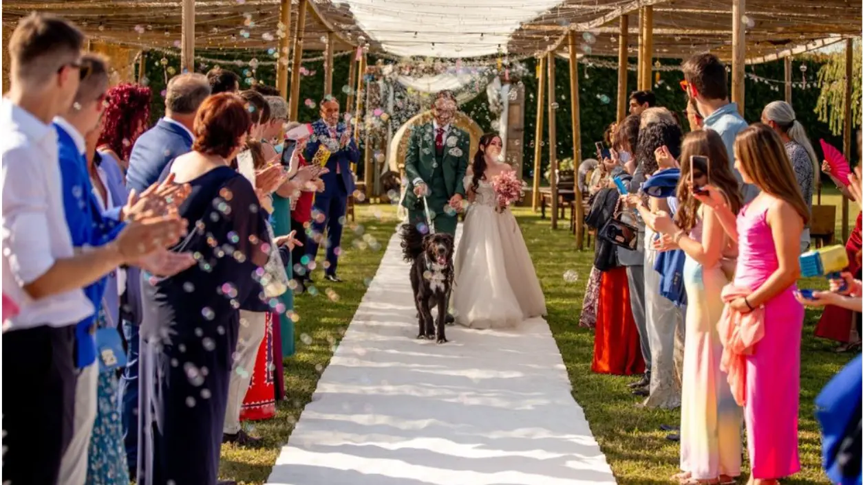 Sposi con il loro cane percorrono la navata della cerimonia nel giardino dell’Antico Ristoro del Ticino