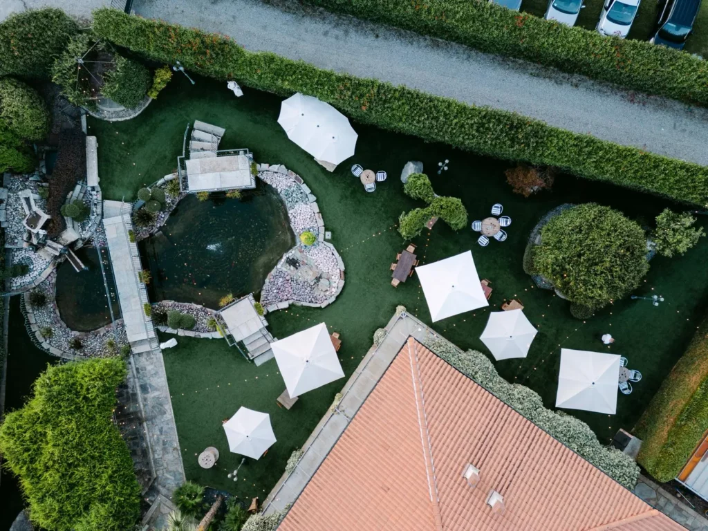 Vista dall’alto del giardino con laghetto, ponticelli e aree relax dell’Antico Ristoro del Ticino