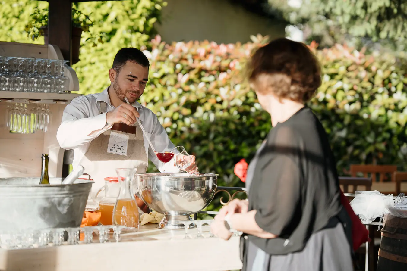 Bartender prepara un cocktail durante l’aperitivo di matrimonio nel porticato