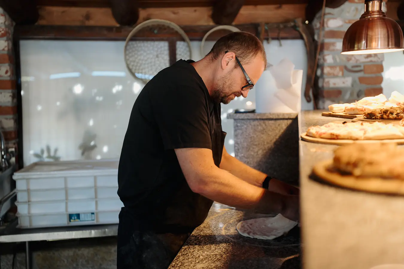 Cuoco prepara pizze e focacce per il buffet nel porticato