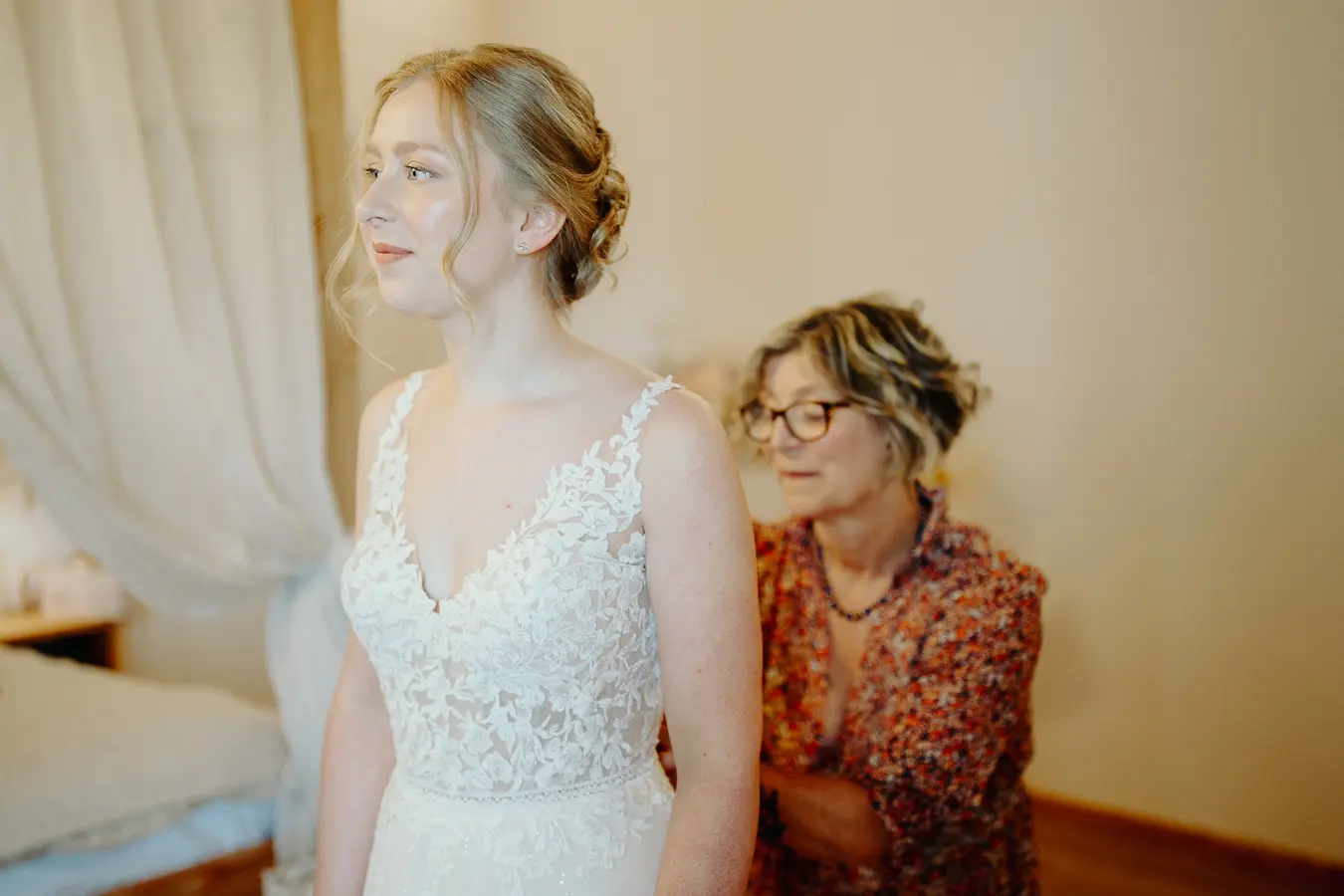 Sposa aiutata a indossare l’abito durante i preparativi nella camera dell’Antico Ristoro del Ticino