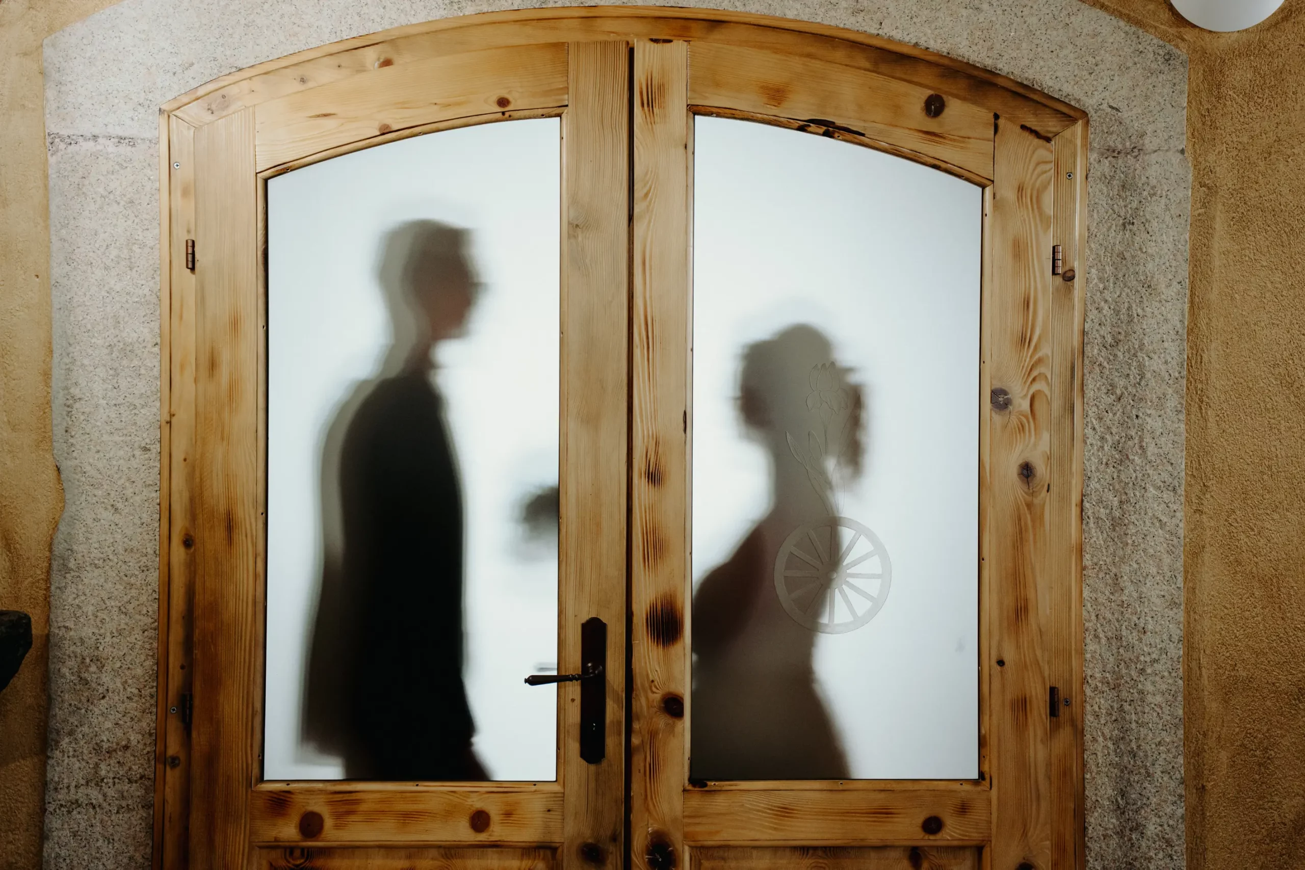 Sagome degli sposi dietro la porta in vetro della Sala Volte all’Antico Ristoro del Ticino