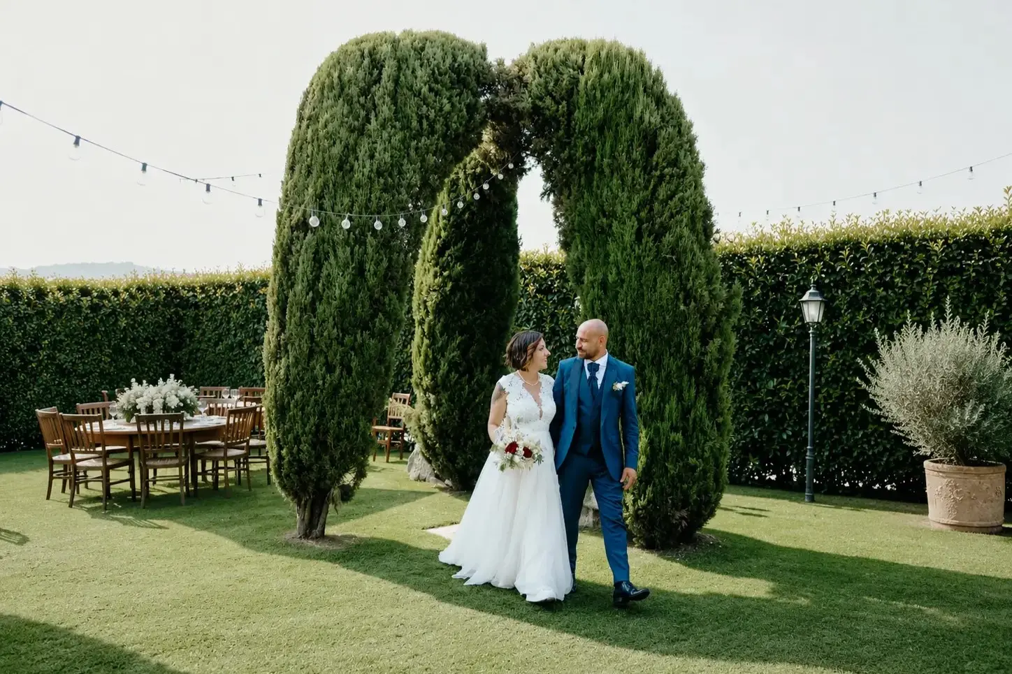 Sposi nel giardino sotto l’arco naturale di cipressi dell’Antico Ristoro del Ticino