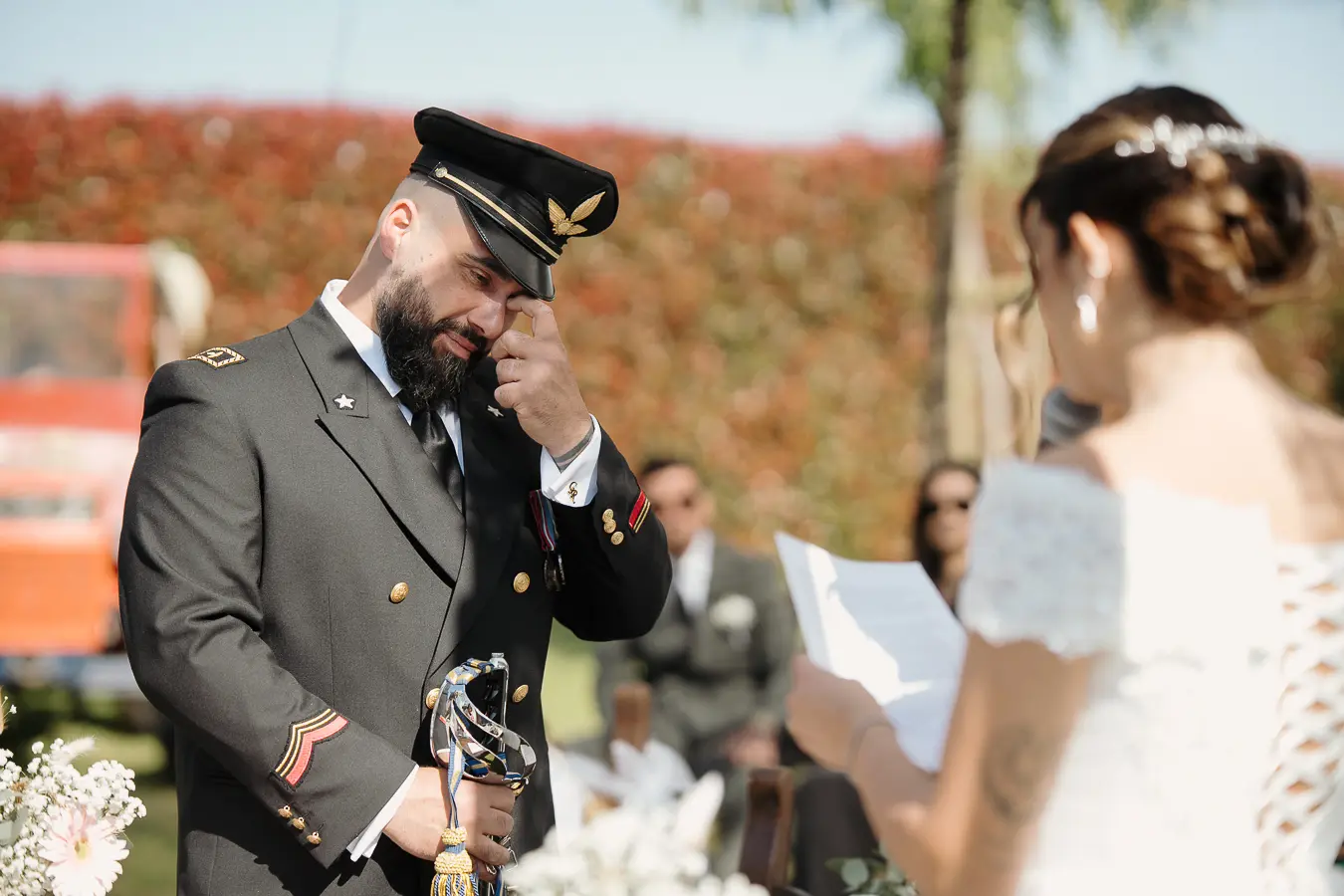 Sposo in uniforme commosso durante la lettura delle promesse nella Tela Verde