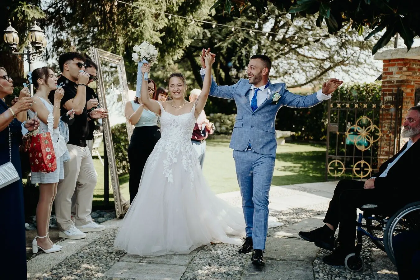 Sposi festeggiano l’uscita dalla cerimonia nel giardino dell’Antico Ristoro del Ticino